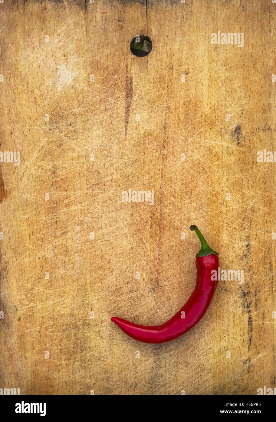 A pod of red hot chili peppers on the old worn wooden background Stock ...