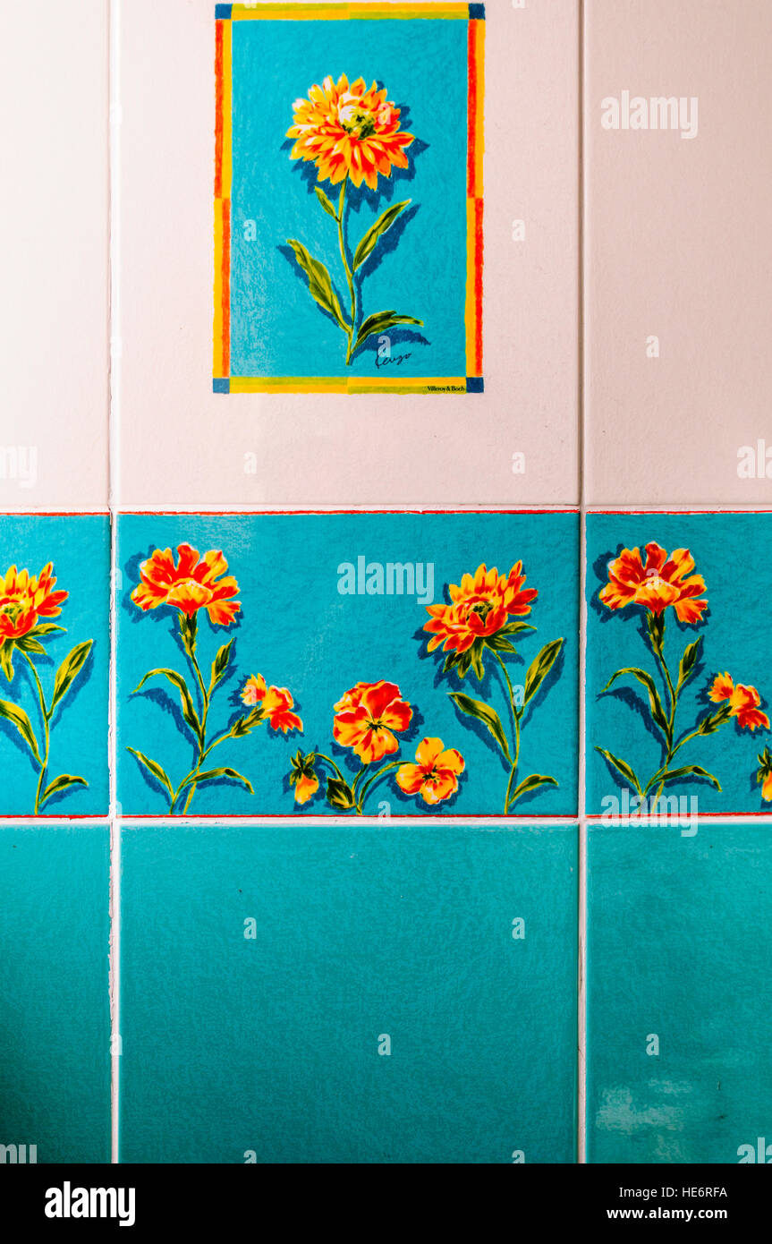 Old blue, orange and white wall times from the 1970s with painted flowers. Stock Photo