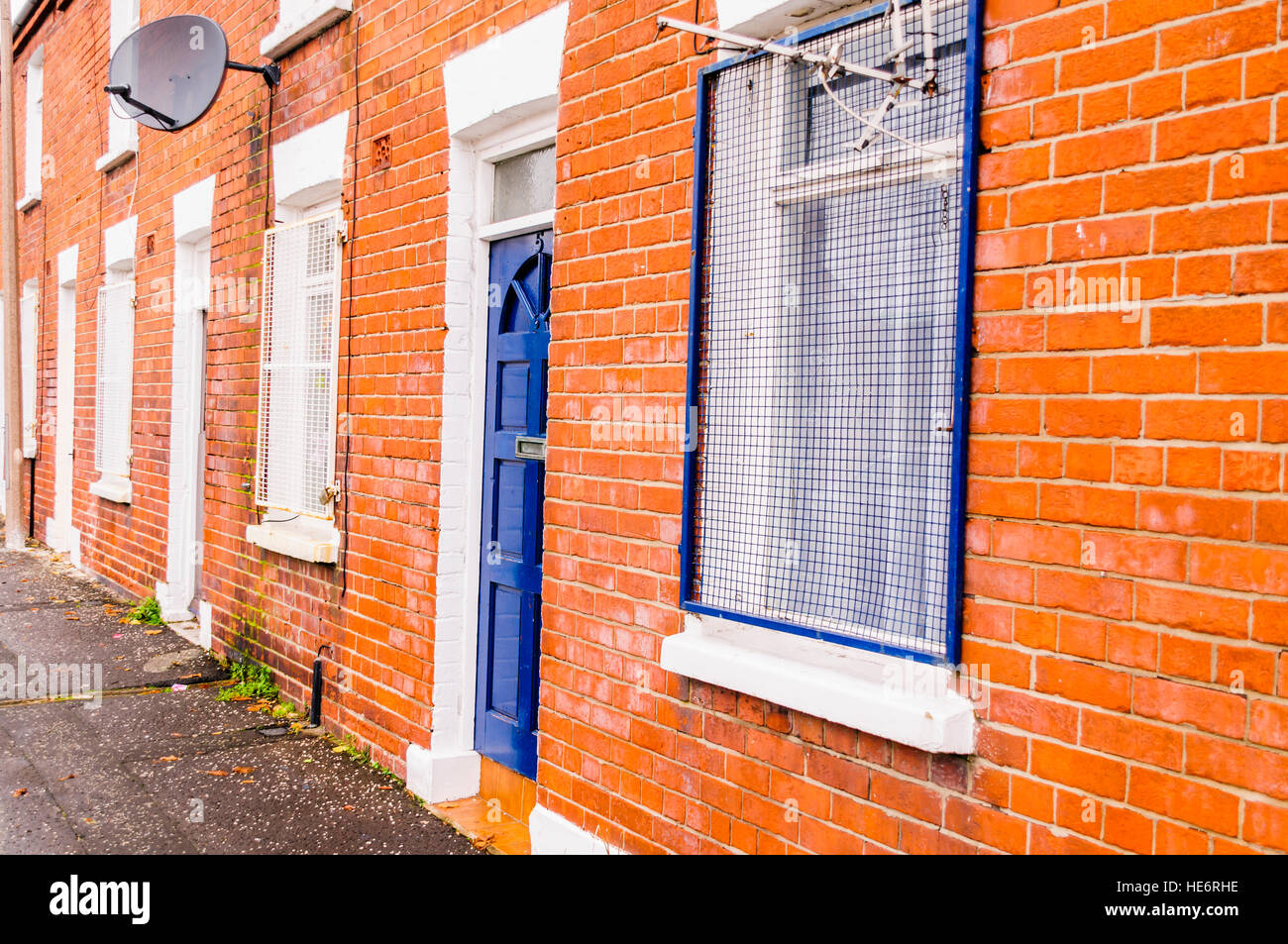 Steel grilles on the windows of houses, to protect against vandalism, in an interface area of Belfast. Stock Photo