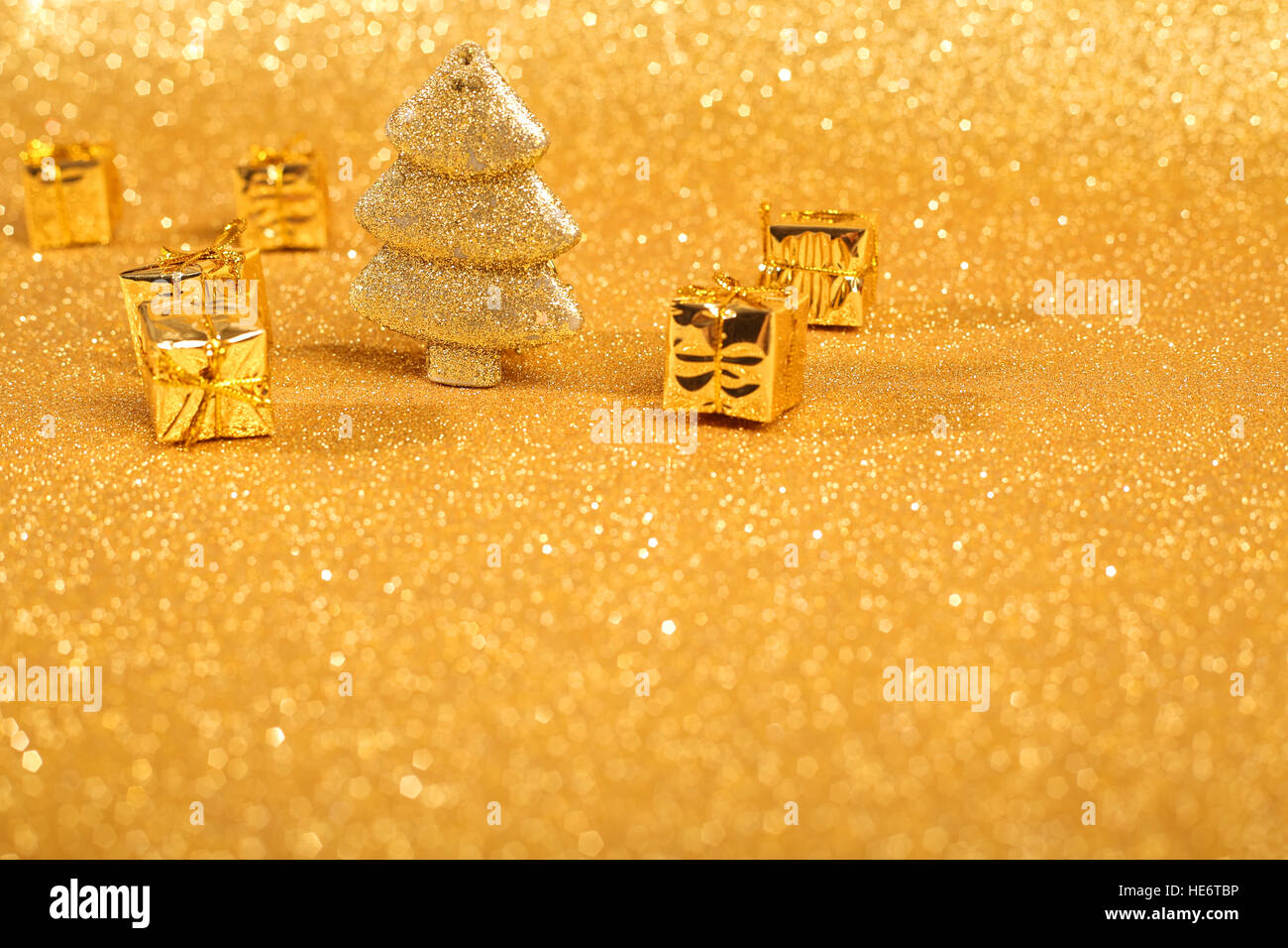 Golden christmas fir tree and gifts decoration on glitter background ...