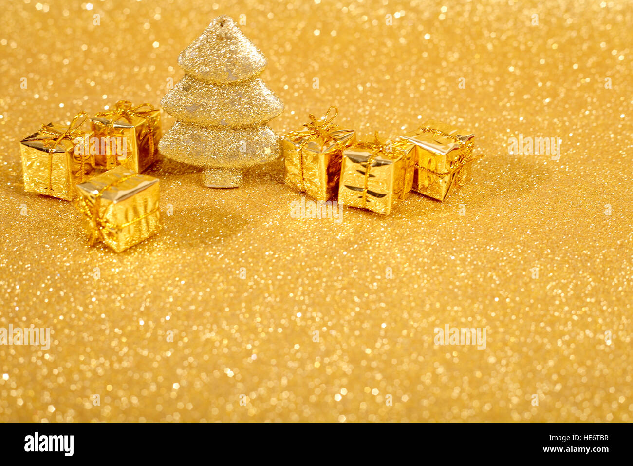 Golden christmas fir tree and gifts decoration on glitter background ...