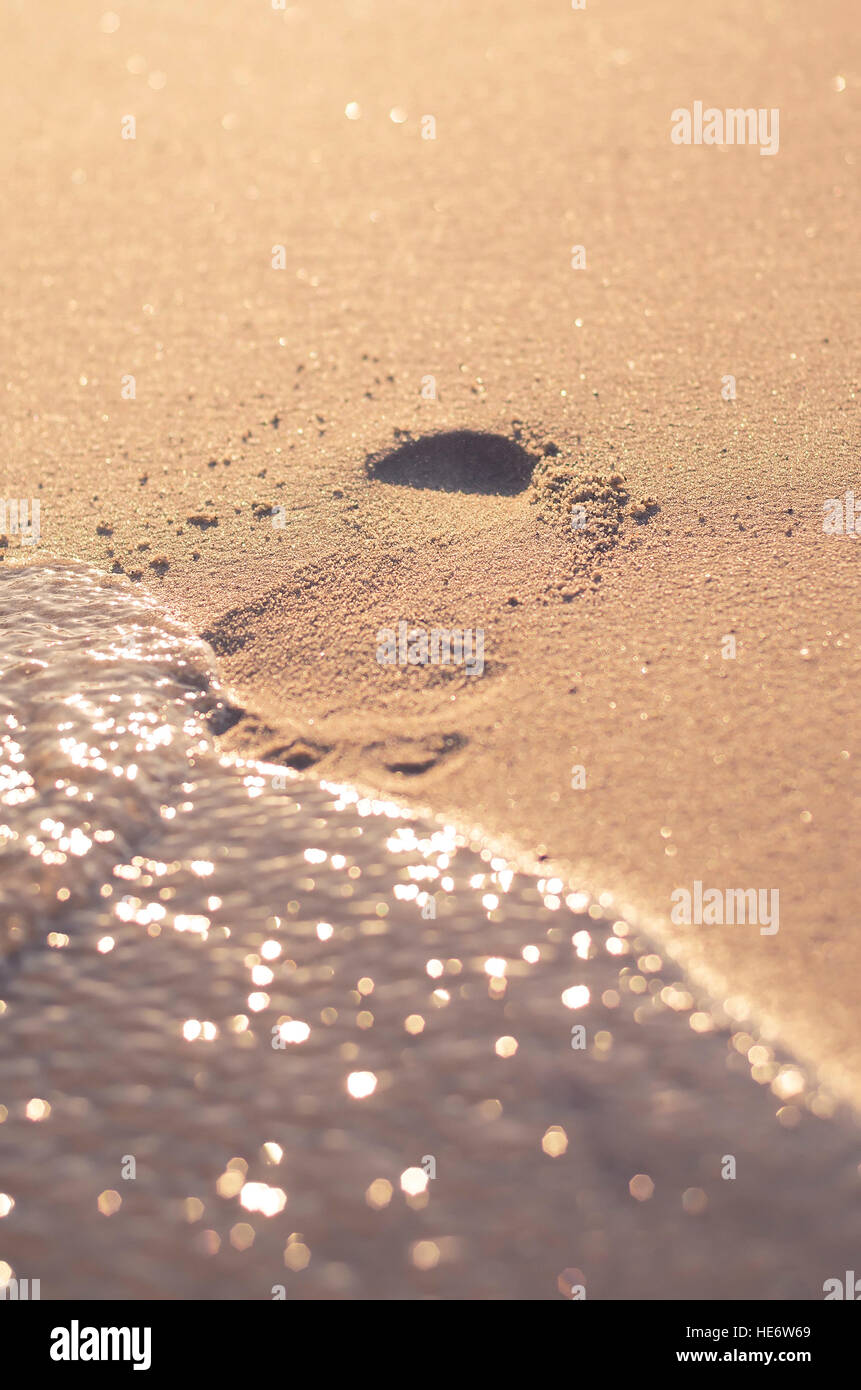 Footprint on the beach snow about to be washed away. Stock Photo