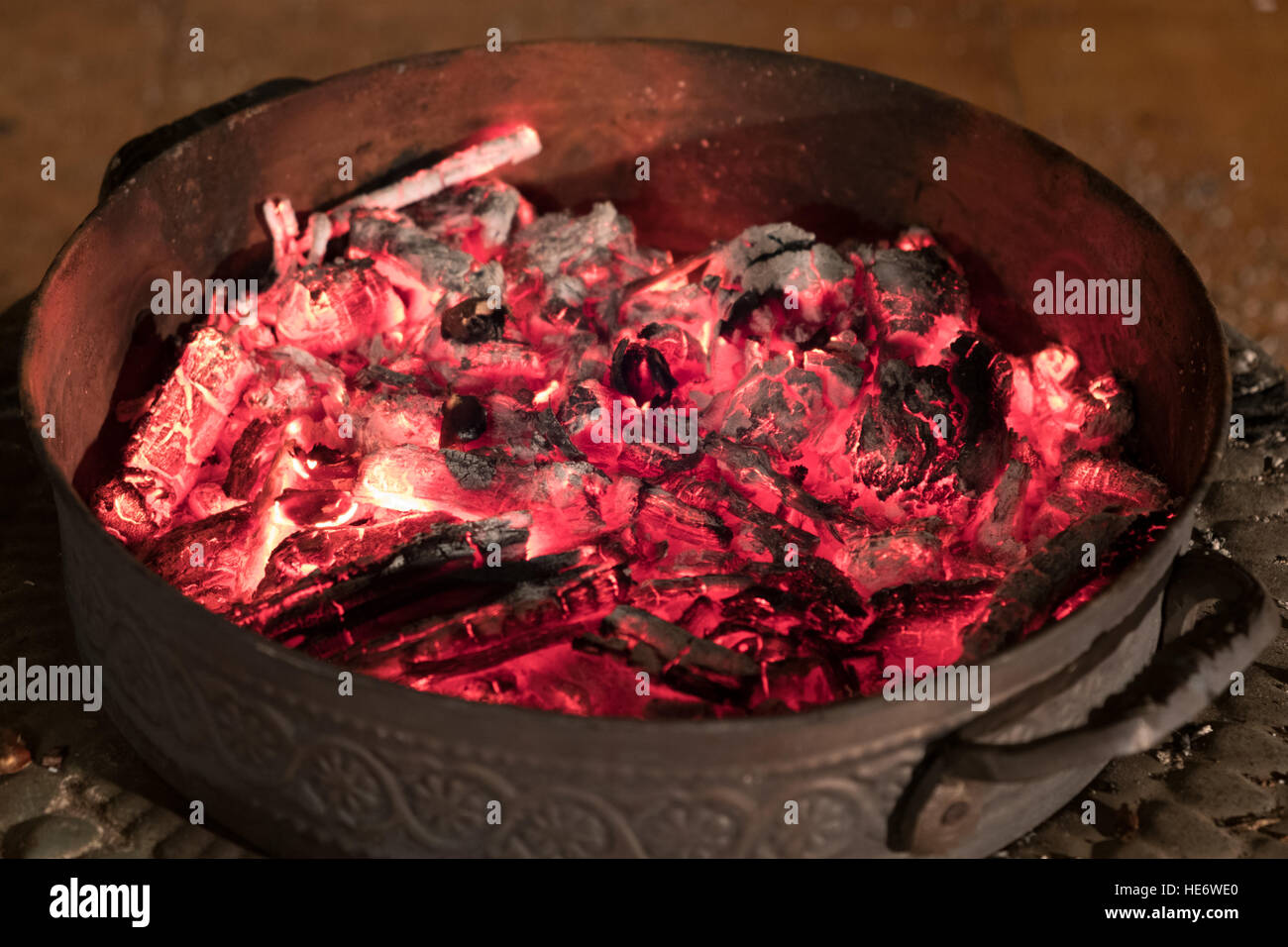 coal glowing in round metal fireplace Stock Photo