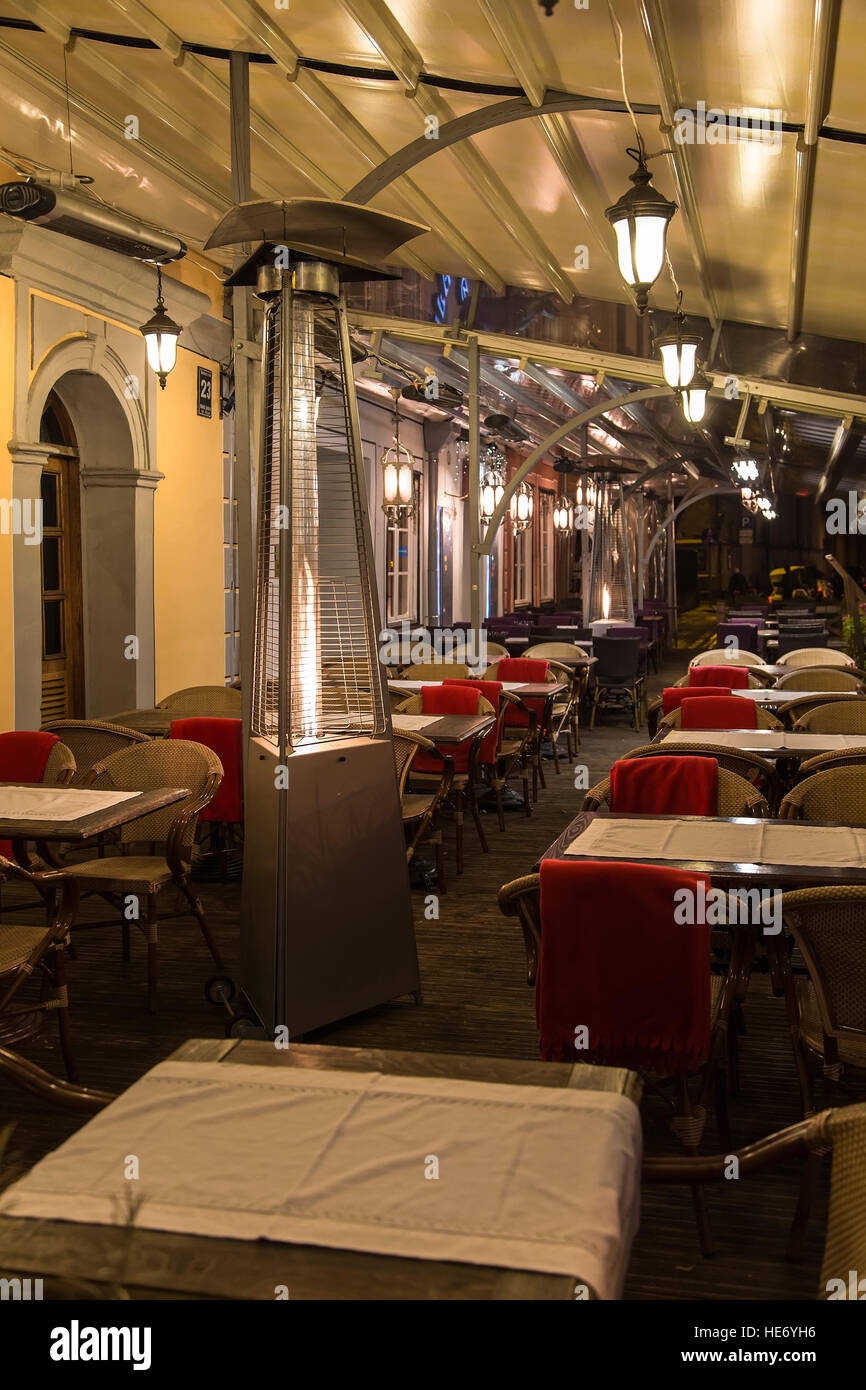 Street cafe with red plaid and a gas heater in the foreground Stock Photo