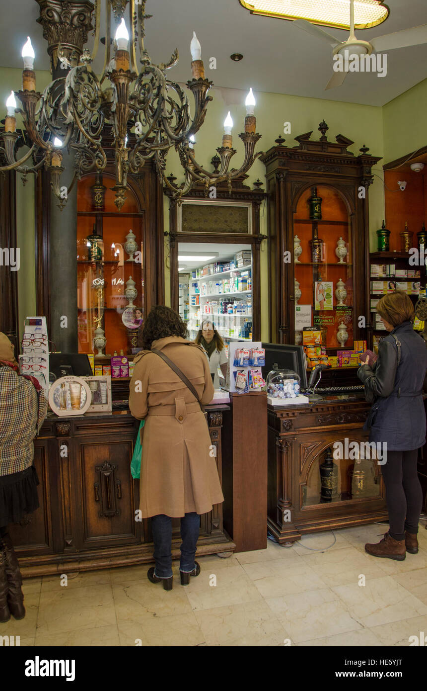 Clients, Interior of vintage pharmacy, farmacia, medicines, chemist, Malaga, Costa del Sol, Andalucia, Spain Stock Photo
