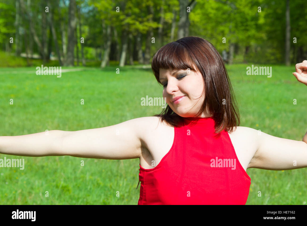 girl in red and green green grass. Park and beauty Stock Photo - Alamy