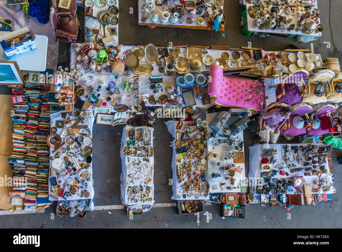 A view from above of an indoor flea market in Barcelona, Spain with an eclectic assortment of items for sale and a male vendor. Stock Photo