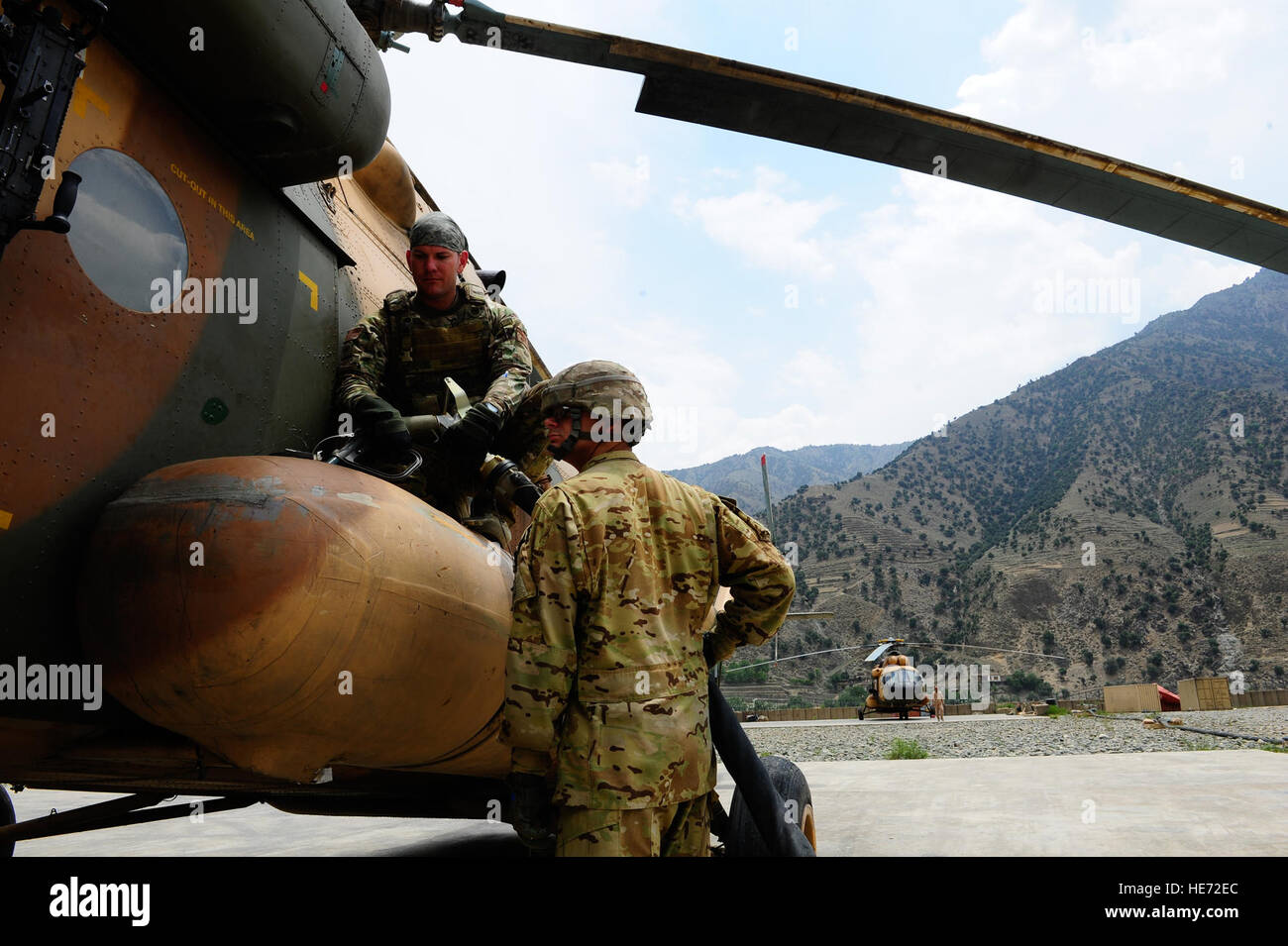 U.S. Air Force Tech. Sgt. Miguel Acevedo, top, fills the fuel tank of an Mi-17 helicopter for a resupply mission July 8, 2012, at Forward Operating Base Bostick in Kunar province, Afghanistan. The joint mission of the Afghan air force and U.S. Air Force Mi-17 helicopter crews was to resupply Afghan forces in remote locations.  Staff Sgt. Quinton Russ Stock Photo