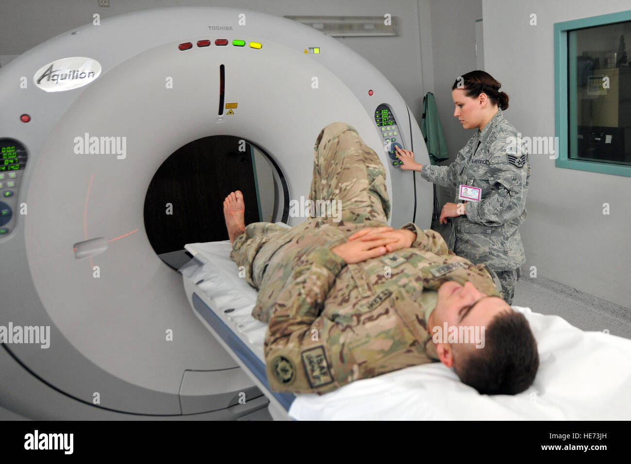 U.S. Army Sgt. Karl Berlinger has a computerized tomography scan done on his right foot with assistance (from) Staff Sgt. Brandy Bisson, diagnostic imagery CAT scan technician, Feb. 12, 2014, Landstuhl Regional Hospital, Germany. Berlinger and his unit were on their way back to Kandahar Airfield, Afghanistan, after a perimeter patrol when they got hit by an improvised explosive device, which blasted the vehicles door inward slamming across Berlinger's right foot. (U.S. Force photo/Senior Airman Chris Willis) Stock Photo