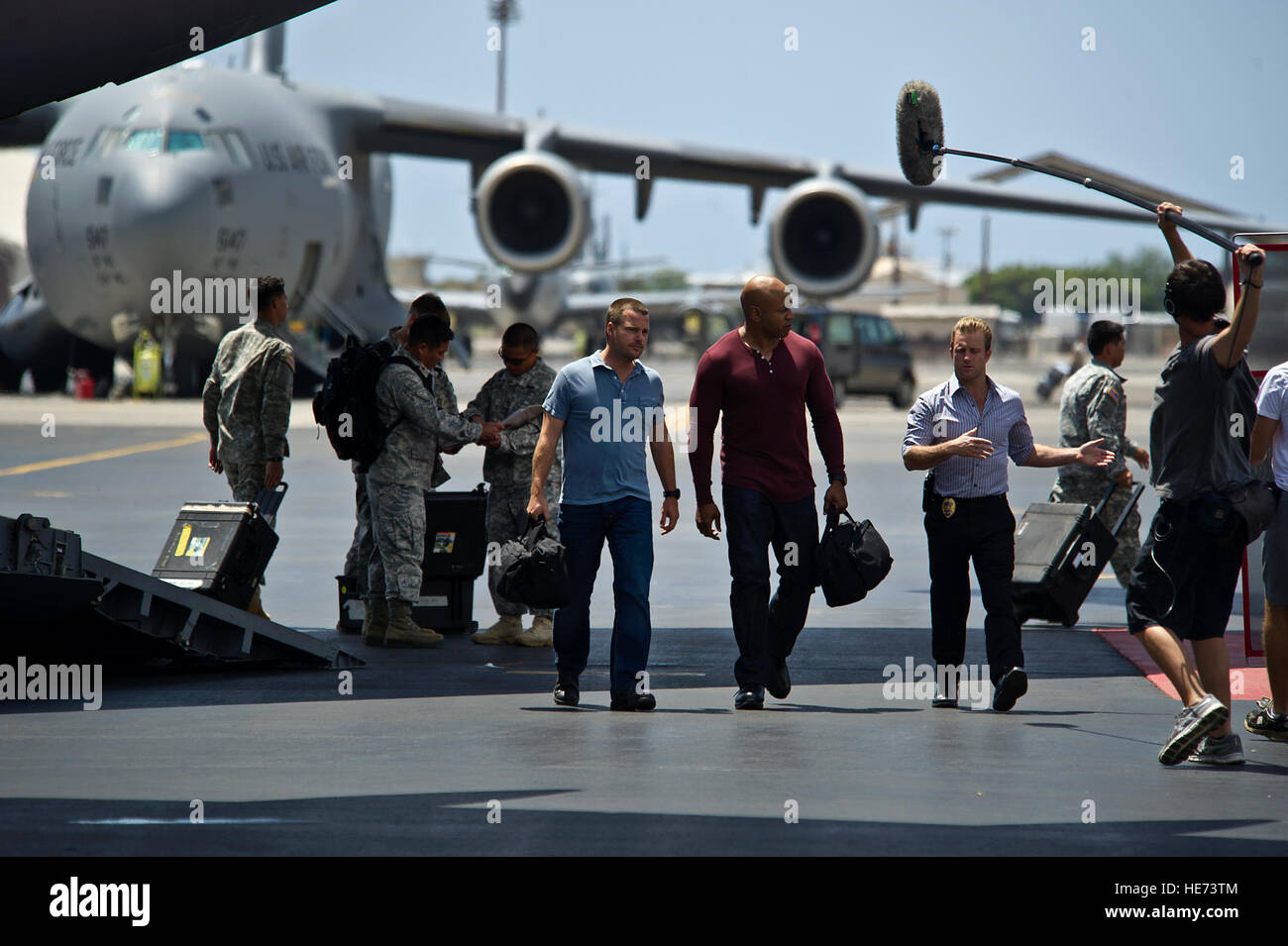 Actors Chris O'Donnell, LL Cool J, and Scott Caan of 'NCIS: Los Angeles' and 'Hawaii Five-0' act out a scene during a recent episode of the CBS hit show 'Hawaii Five-0' episode at Joint Base Pearl Harbor-Hickam on March 26, 2012. U.S. Air Force airmen and Hawaii Army National Guard soldiers were cast as  background extras during the filming. Stock Photo