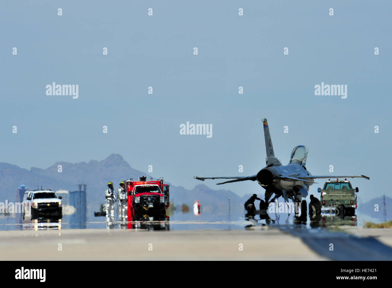 The 355th Civil Engineer Squadron fire emergency personnel inspect an F-16 Fighting Falcon after the aircraft engaged an aircraft arresting system at Davis-Monthan Air Force Base, Ariz., April 11, 2015. The F-16 was used to certify the new AAS that was installed March 28.  Airman 1st Class Chris Massey Stock Photo