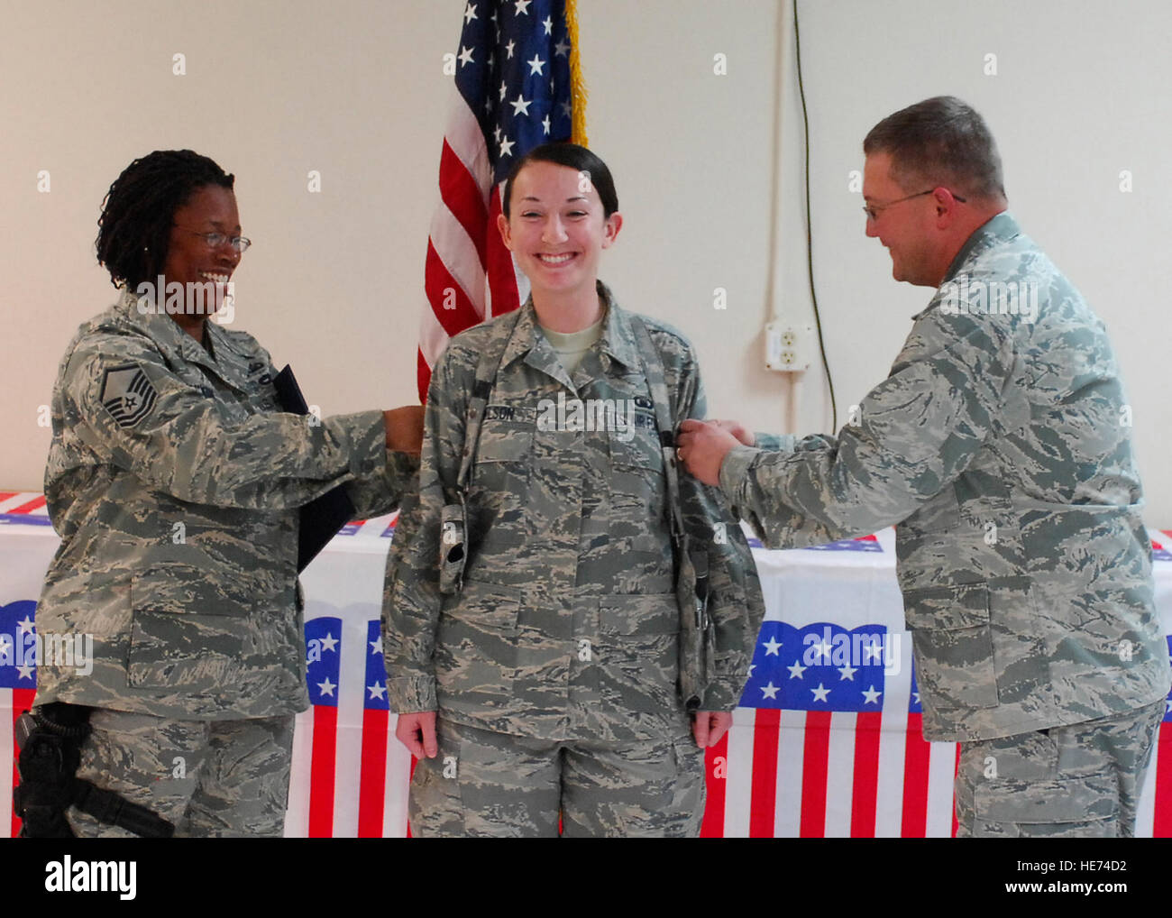 A ceremony was held for newly promoted Staff Sgt. Jessica Wilson (middle), a chaplain assistant from the 455th Air Expeditionary Wing, during a wing-staff luncheon, Nov. 1. Master Sgt. Nicole Nixon (left) and Lt. Col. Randall Kitchens (right) "tack on" stripes for Wilson. Wilson, a West Palm Beach, Fla., native, is deployed from Vance Air Force Base, Okla. Nixon, a chaplain assistant from the 455th AEW, is deployed from Ramstein Air Base, Germany, and hails from Chicago, Ill. Kitchens, a chaplain from the 455th AEW, is deployed from Peterson AFB, Colo., and hails from Macon, Ga. Stock Photo