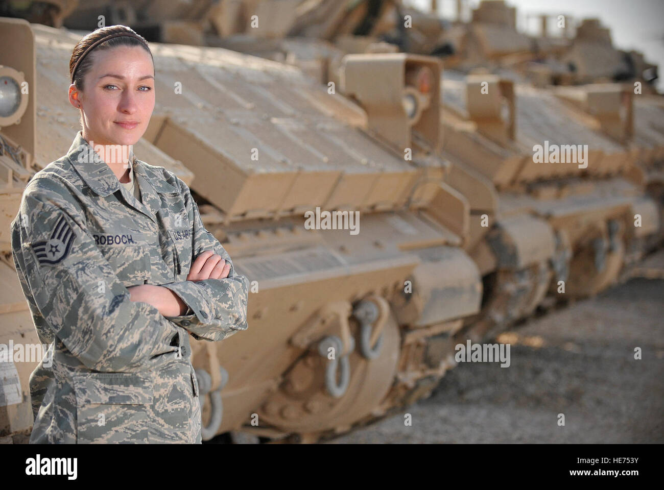 Staff Sgt. Esther Roboch, Tallil redistribution property assistance team's rolling stock NCO in charge, poses for a photo in front of a line of Bradley tanks March 5, 2011, at Ali Air Base, Iraq. Sgt. Roboch is a native of Jacksonville, Fla. Stock Photo