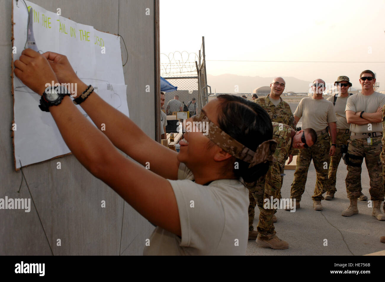 Senior Airman Crystal Cuyan, 651st Expeditionary Aeromedical Evacuation Squadron, plays pin the tail on the C-130 as members of the 651st EAES and the 772nd Expeditionary Airlift Squadron watch August 12, 2013, at Kandahar Airfield, Afghanistan. Airmen from the two squadrons teamed up to raise $800 for the Wounded Warrior Foundation.  Senior Airman Jack Sanders) Stock Photo