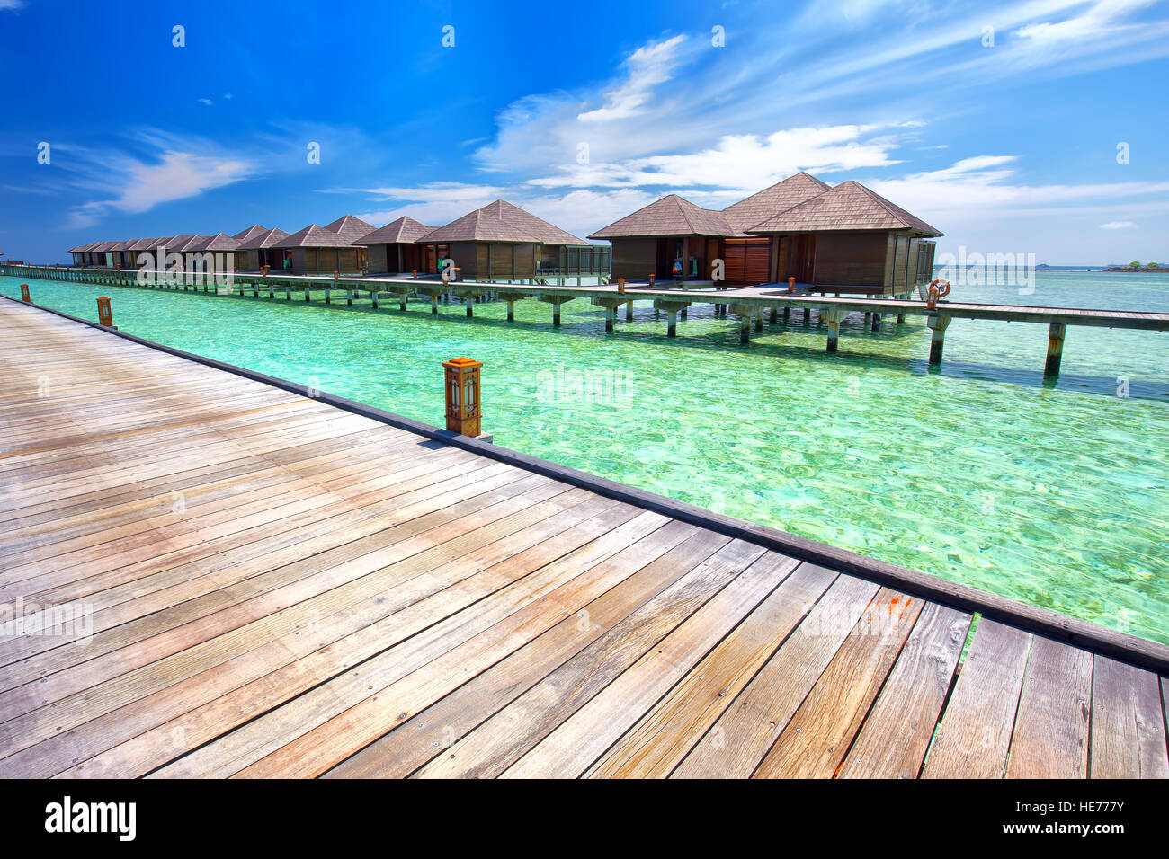 Luxurious water bungalows on tropical island with tourquise clear water. Stock Photo