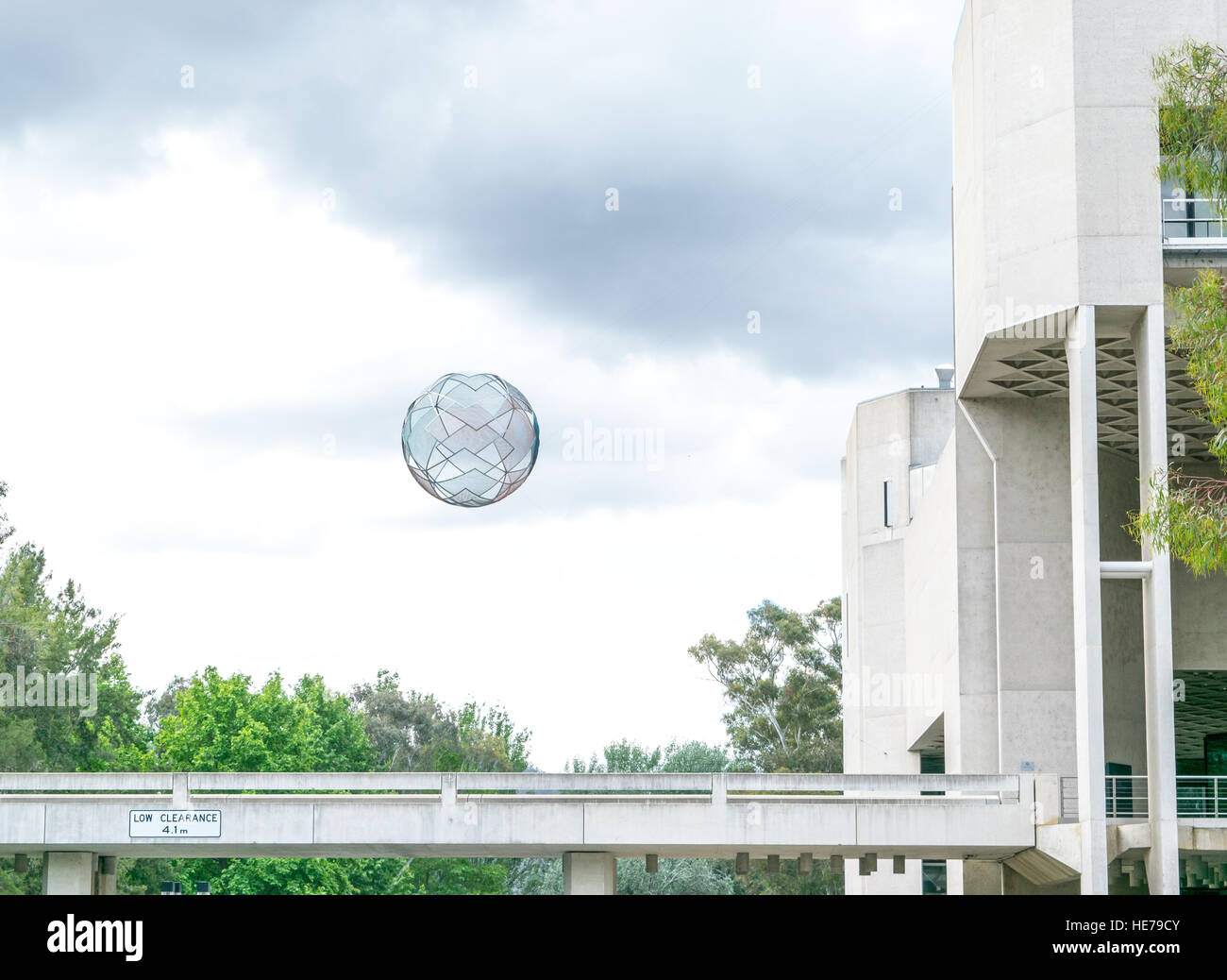 A floating sphere hangs over a walkway in front of the National Gallery of Australia.  A piece of public art called Diamonds. Stock Photo