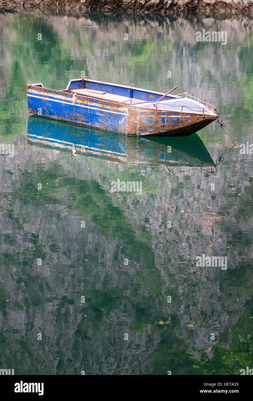 Boat floating on calm green colored lake water Stock Photo