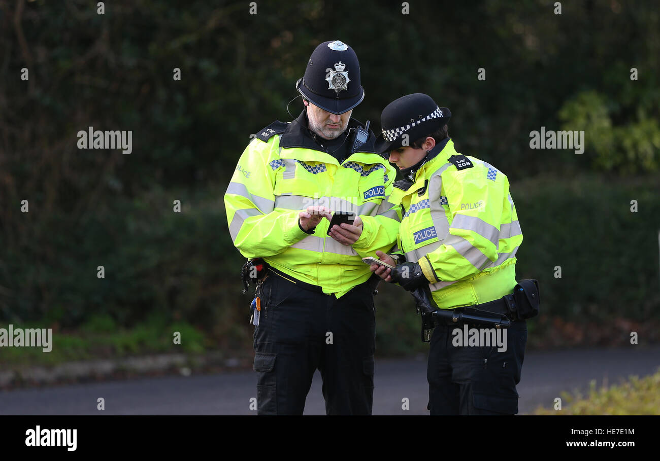 Two UK Police officers looking at a mobile cell phone Stock Photo