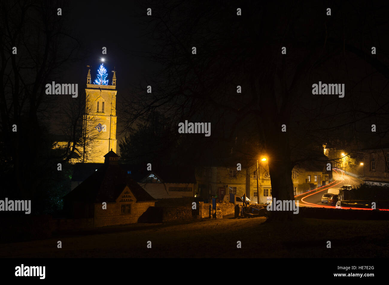 Christmas tree lit up at night on top of Peter & St Paul Church, Blockley, Cotswolds, Gloucestershire, England Stock Photo