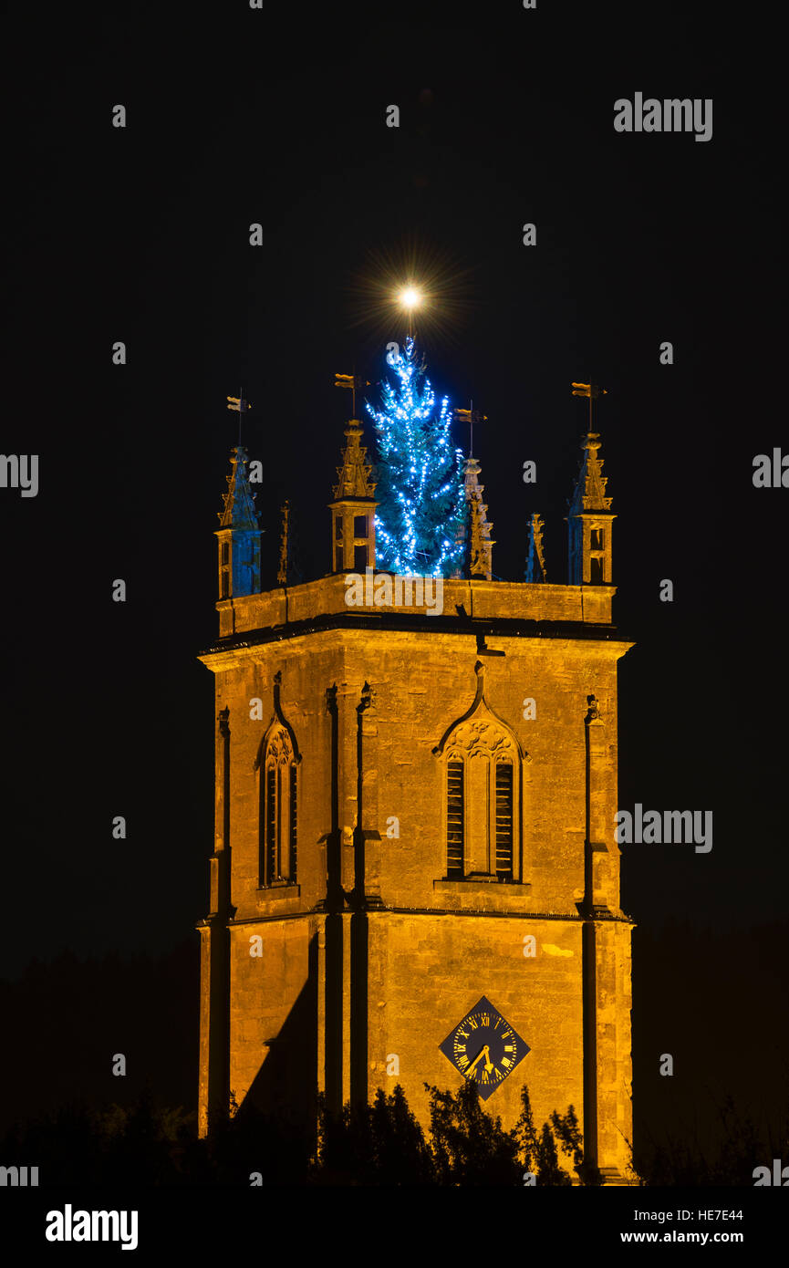 Christmas tree lit up at night on top of Peter & St Paul Church, Blockley, Cotswolds, Gloucestershire, England Stock Photo