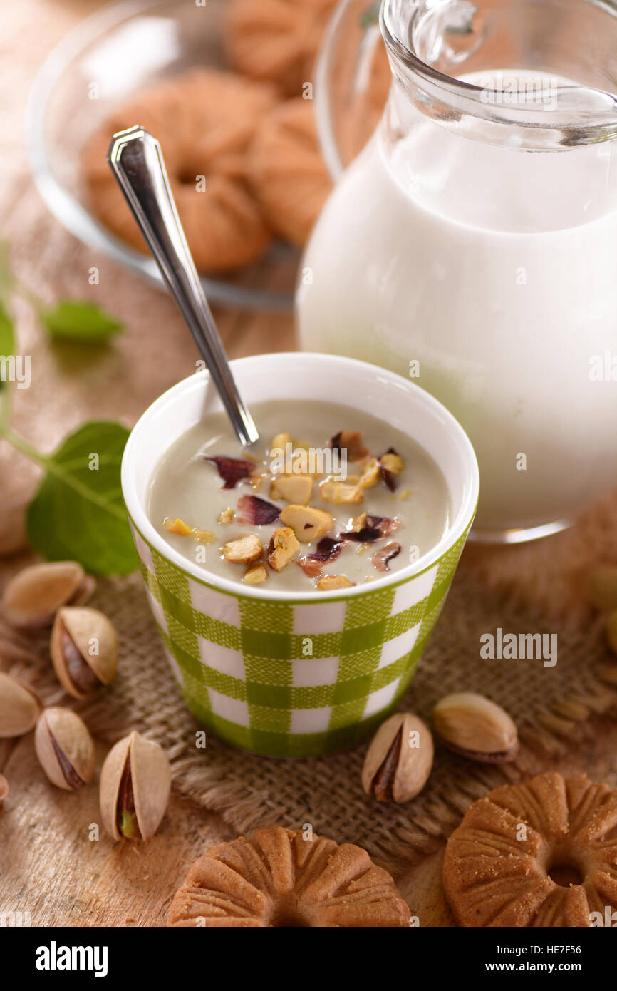 pistachio yogurt in ceramic jar with fruit around Stock Photo Alamy