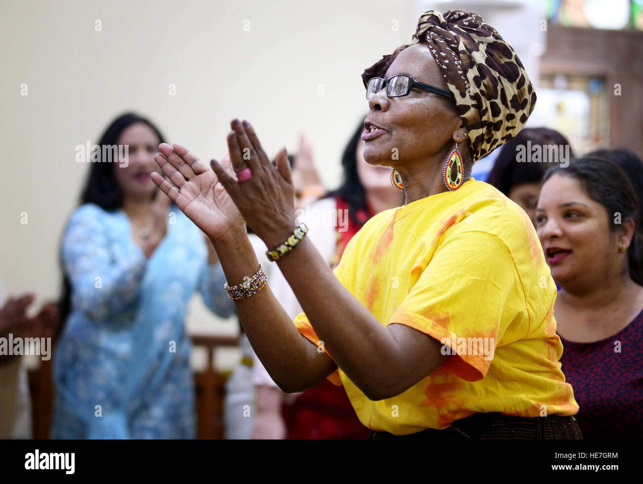 Patricia Mwatu, from Kenya, sings with the Maryhill Integration Nework's Joyous Choir during a community event at the Pollokshields Burgh Hall, Glasgow, to mark UN International Migrants Day. Stock Photo