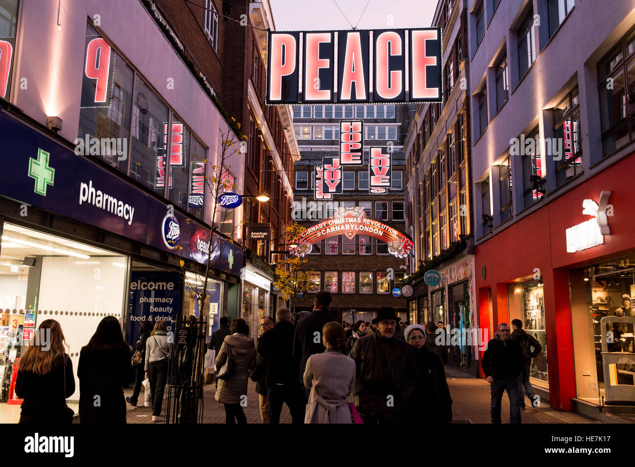 Street view of Carnaby street busy with tourists and people shopping with big Christmas light decorations Stock Photo