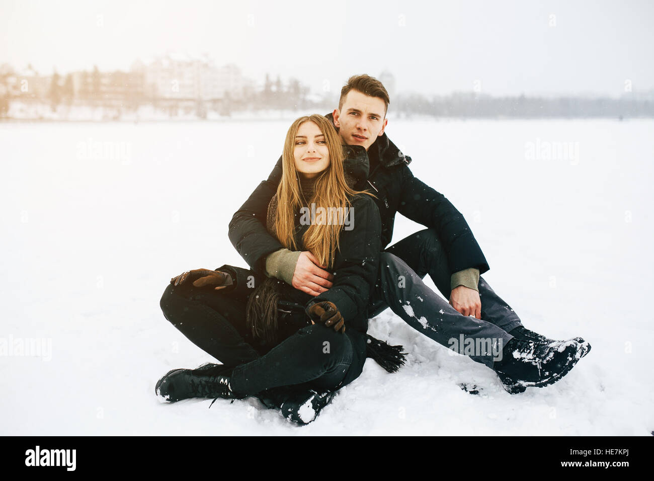 couple sitting on the snow Stock Photo - Alamy