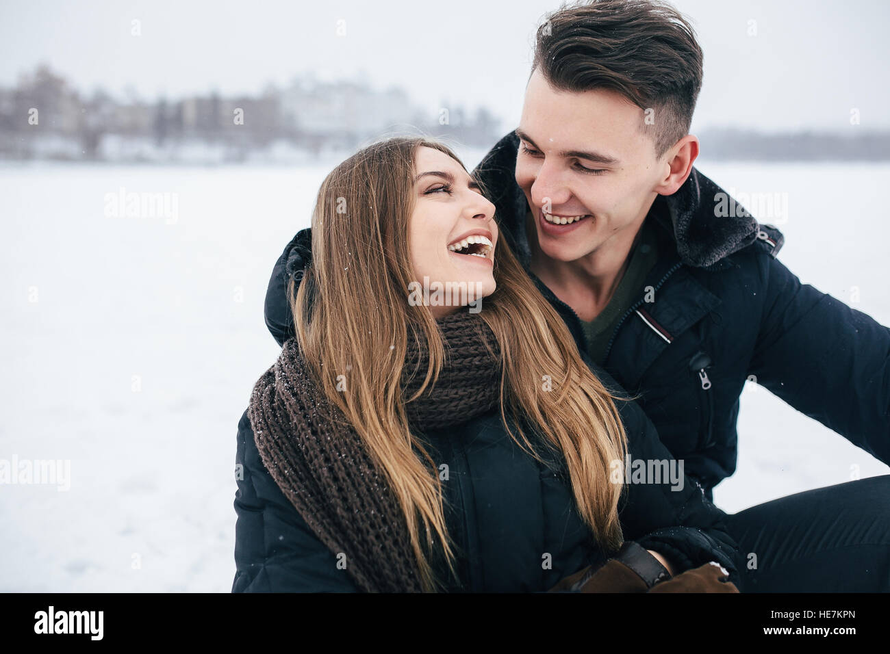 couple sitting on the snow Stock Photo - Alamy