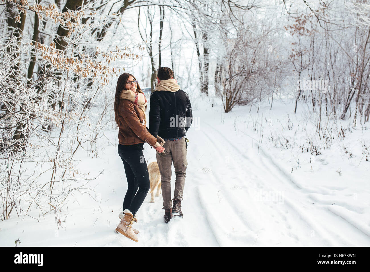 Young couple in love walking with dog Stock Photo - Alamy