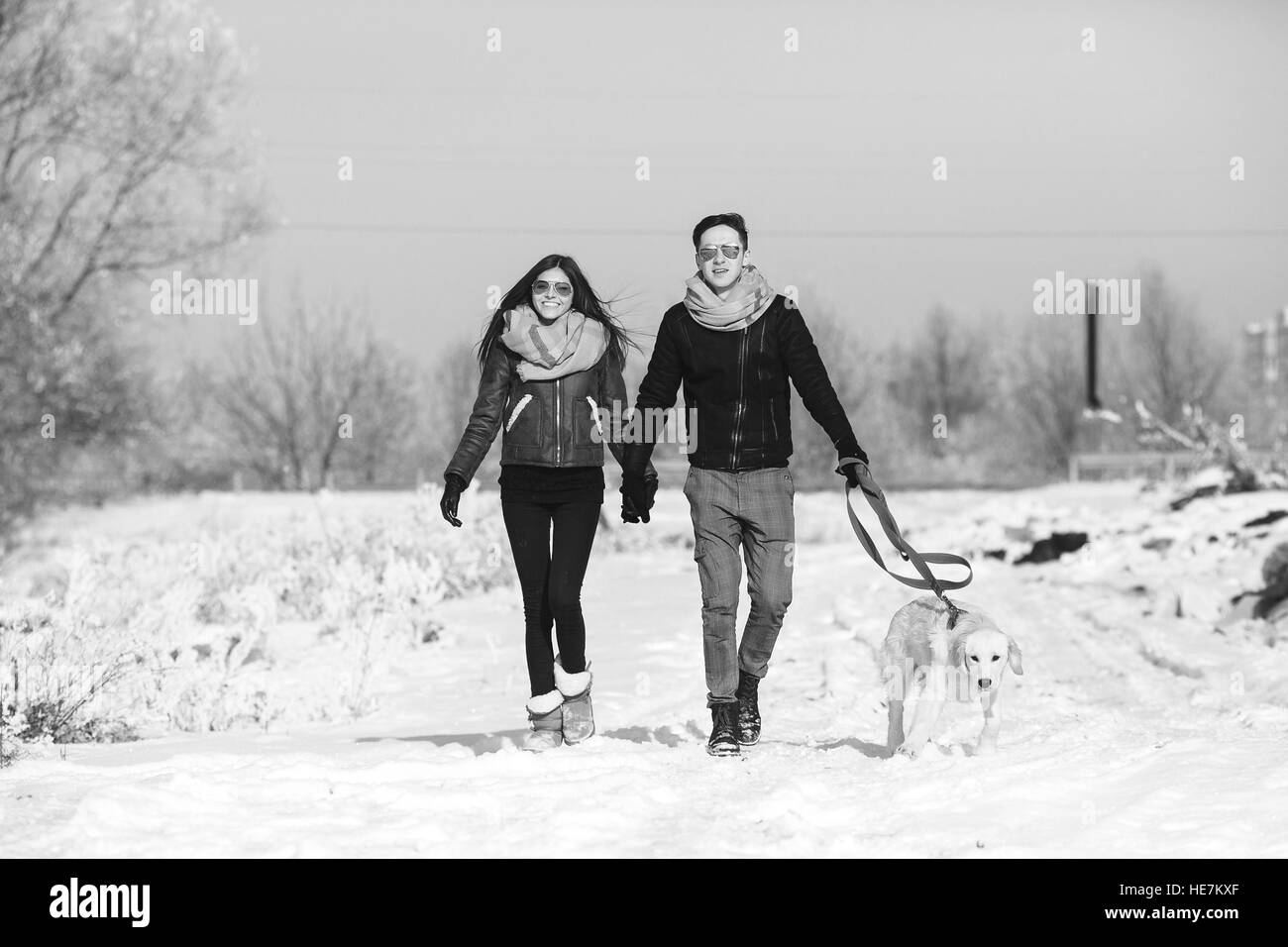 Young couple in love walking with dog Stock Photo - Alamy