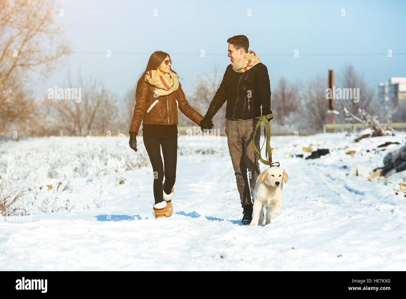 Young couple in love walking with dog Stock Photo - Alamy