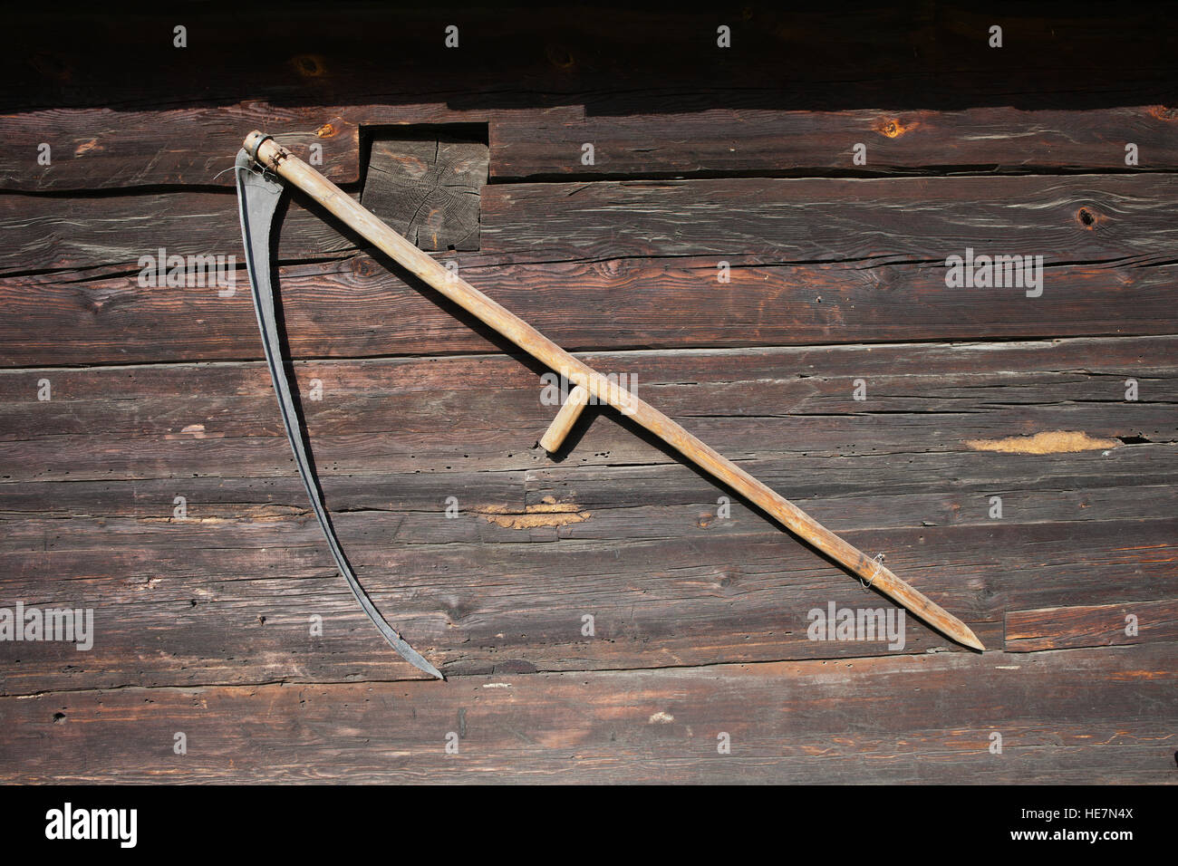 A traditional wooden scythe hanging on barn wall in Museum of Ethnography in Torun, Poland Stock Photo