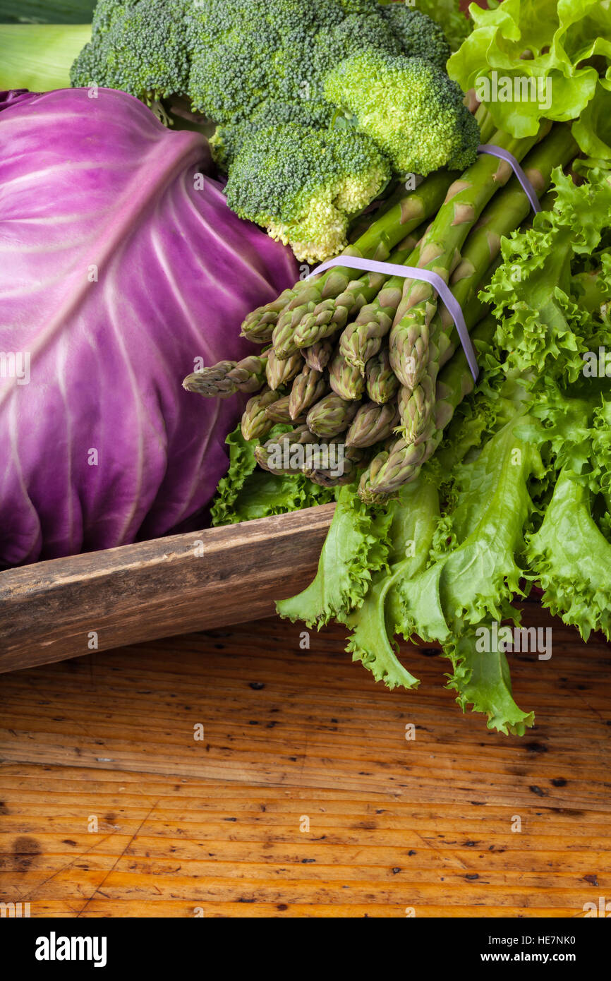 Fresh summer vegetables: cabbage,asparagus,avocado,broccoli and salad - on a wooden table. Stock Photo