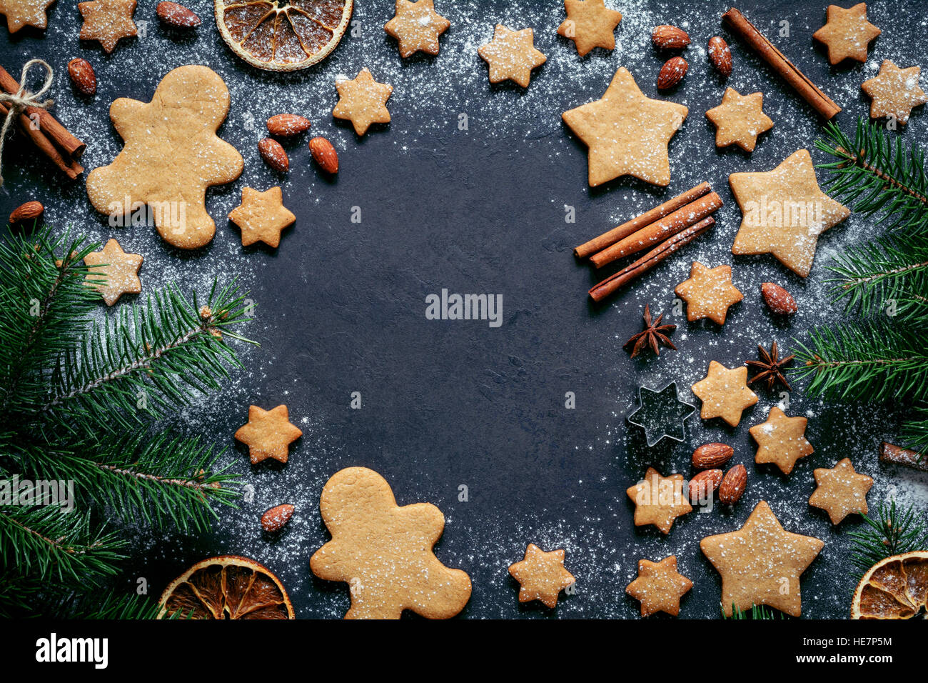 Christmas or New Year background with gingerbread cookies, gingerbread man cookies, stars, spices, cinnamon, fir tree and decor Stock Photo