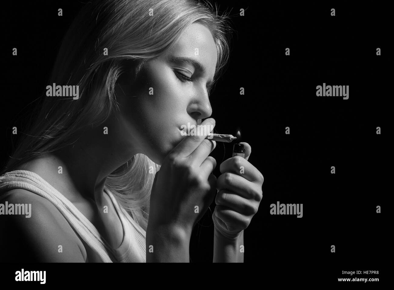 blond young woman smoking on black background, monochrome Stock Photo ...