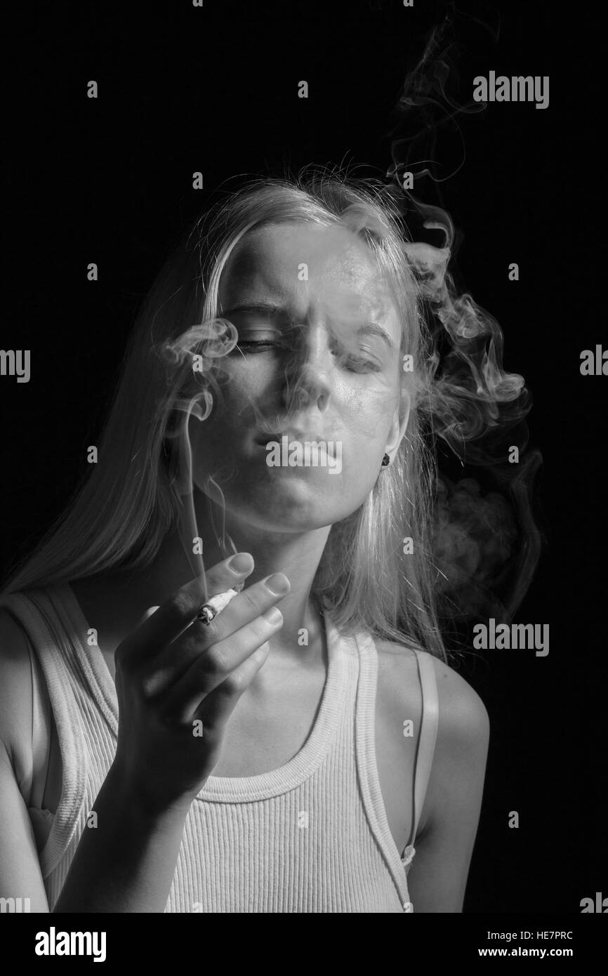blond young woman smoking on black background, monochrome Stock Photo ...