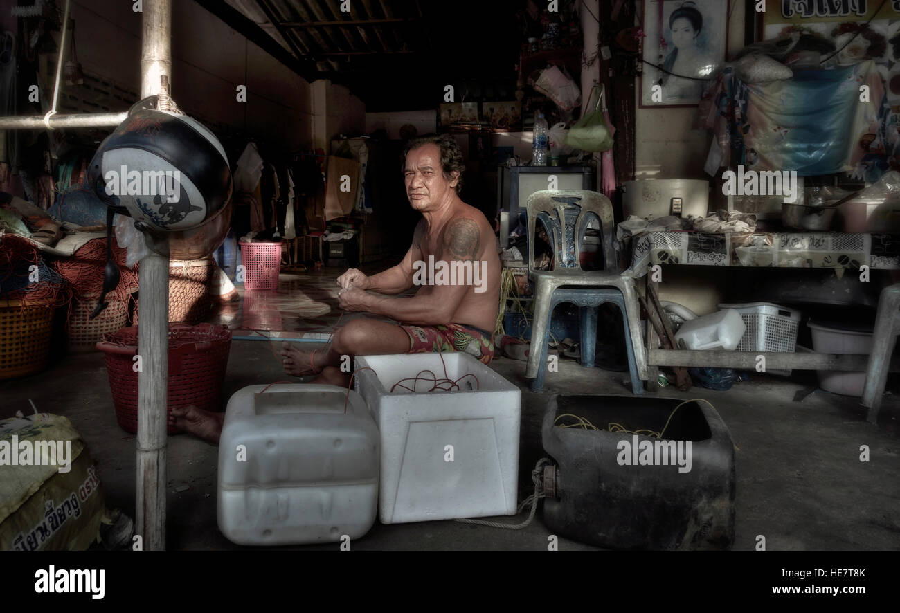 Thailand man repairing fishing nets in his dimly lit workshop. Thailand S.  E. Asia Stock Photo - Alamy