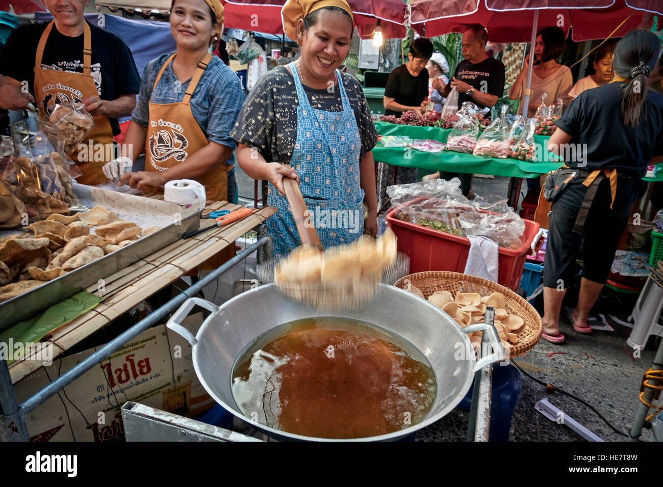 Boiling Fat Thailand street food market with female cooking prawn crackers in hot ...