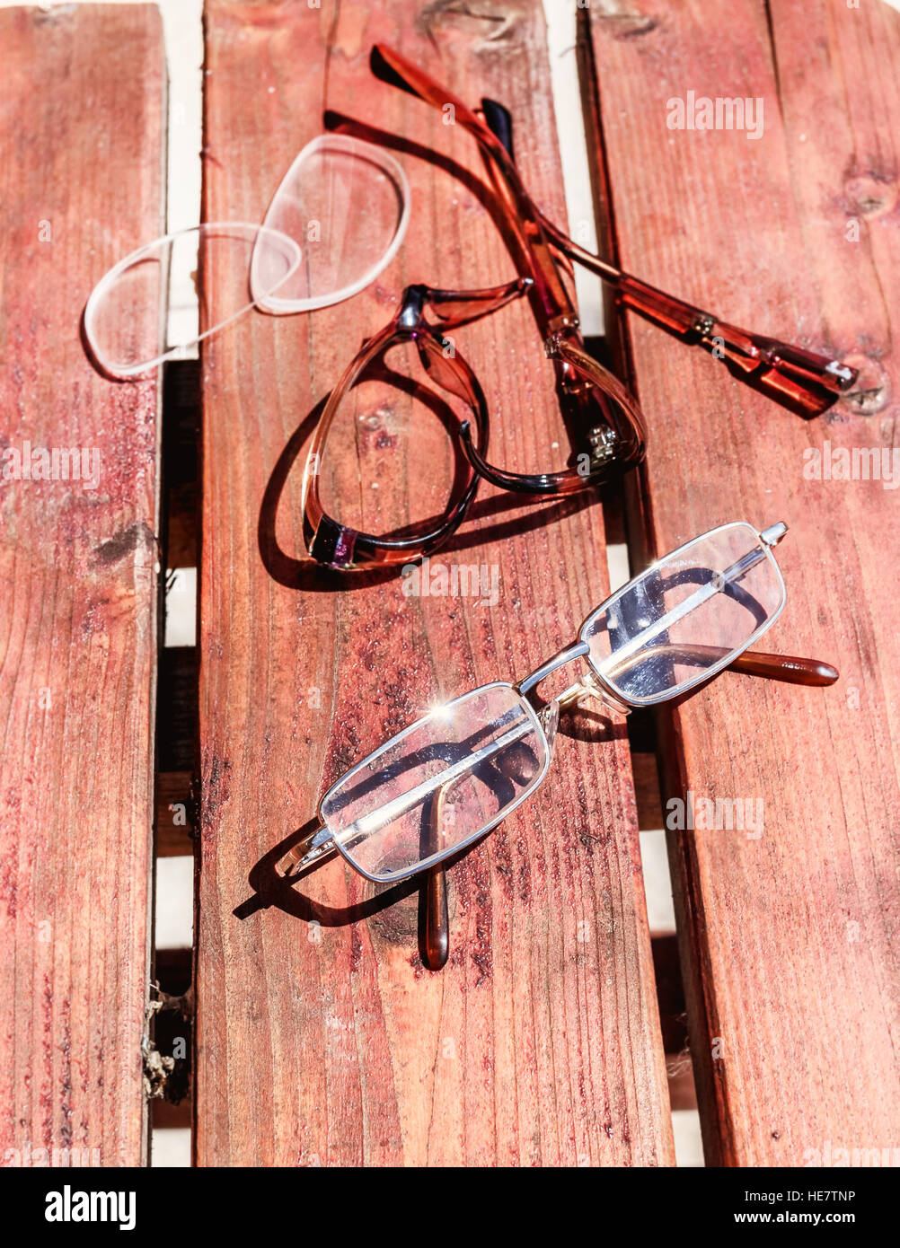 Glasses broken and whole on sunny summer wood Stock Photo