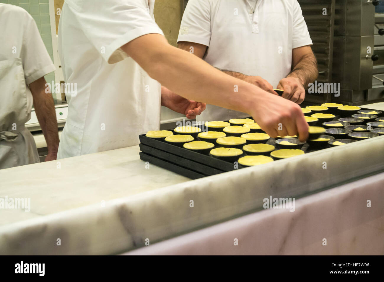Bakers making pastel de nata (custard tart with cinnamon and nutmeg