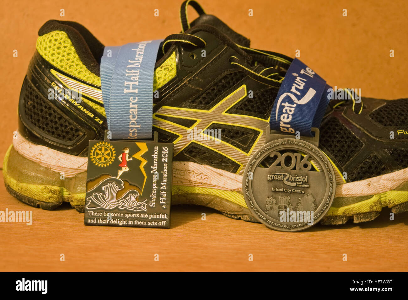 Running shoe with half marathon finishers medals. Stock Photo