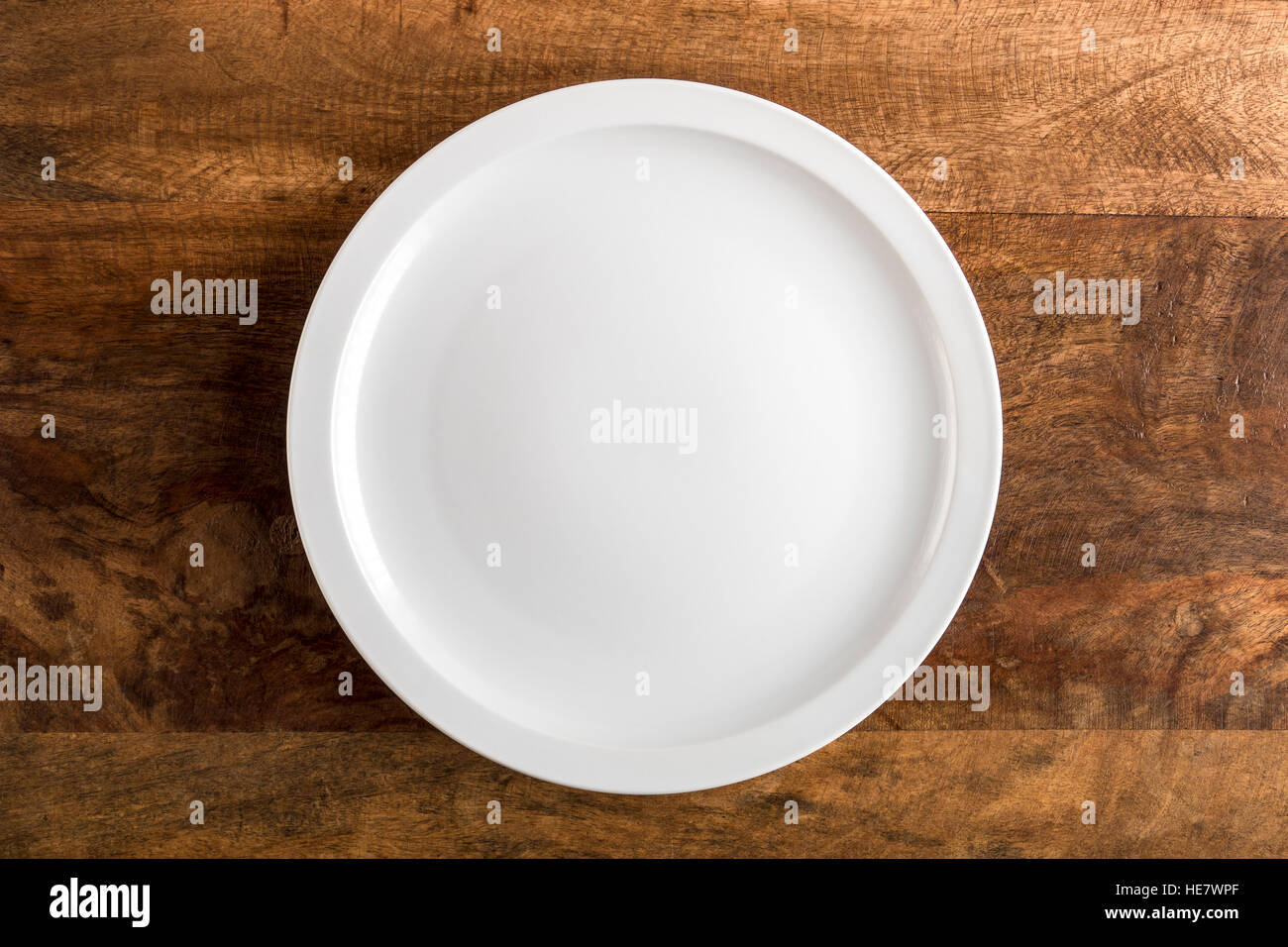 Empty White Plate on Wooden Table Top Stock Photo