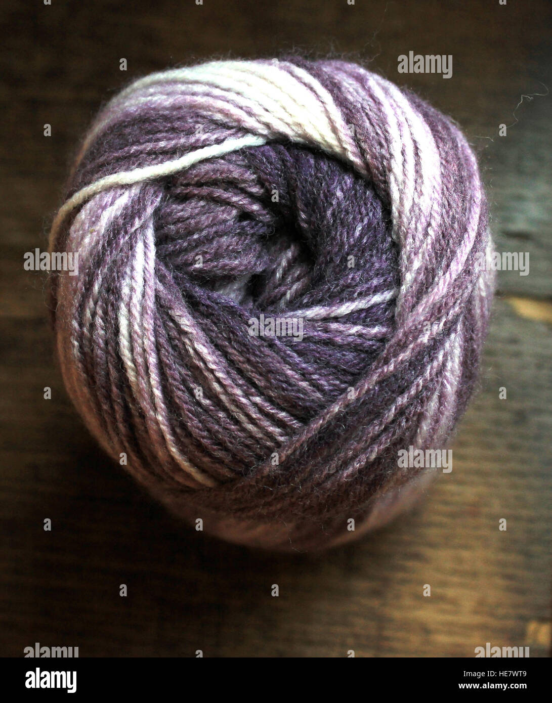 A ball of hand knitting yarn in shades of purple and lilac pictured