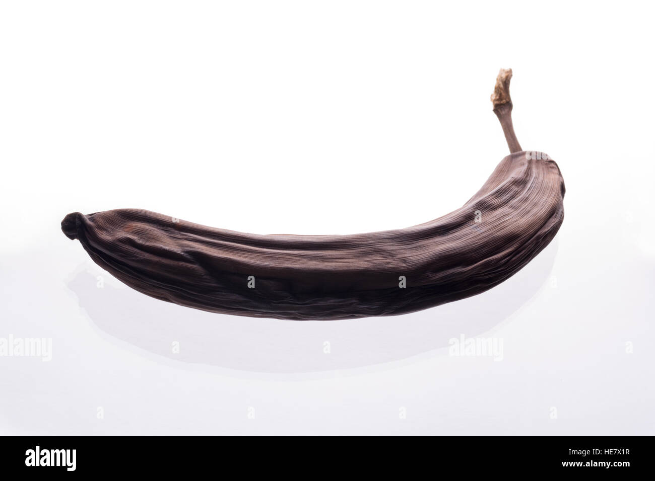 Spoiled brown banana lying on white background Stock Photo