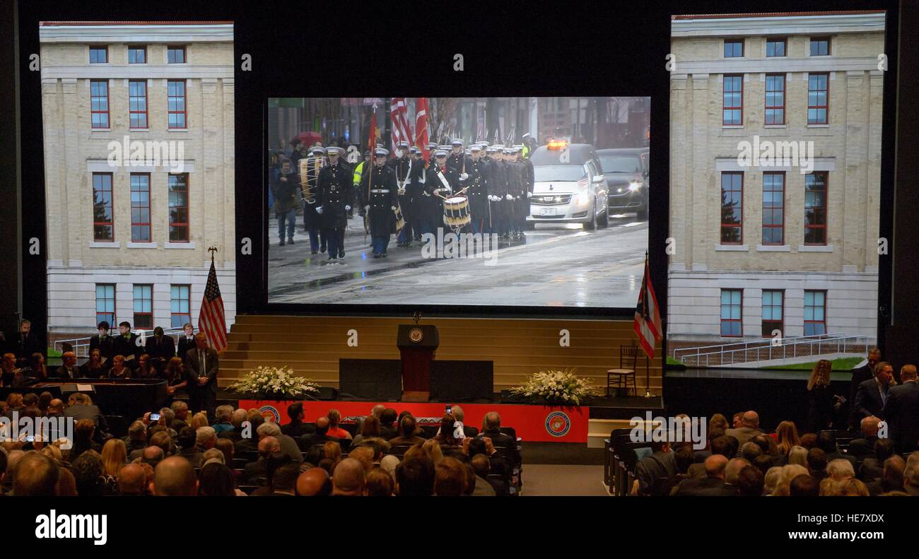 Family, friends, and dignitaries watch a live feed of the procession of  former astronaut and U.S. Senator John Glenn as they gather for a ceremony to celebrate his life at Ohio State University December 17, 2016 in Columbus, Ohio. The former Marine pilot, Senator and first man to orbit the earth died last week at the age of 95. Stock Photo