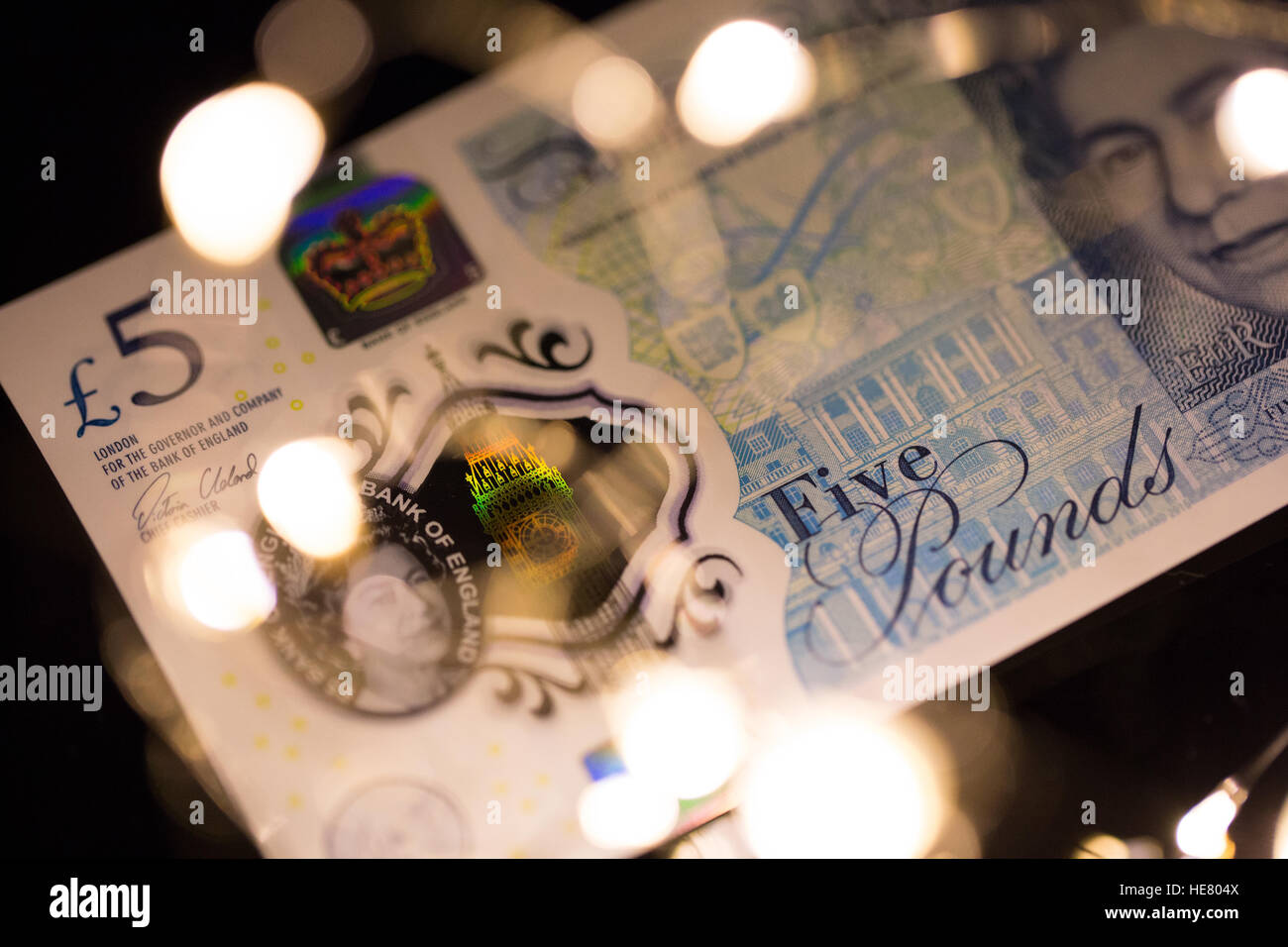 Close up of the new 2016 polymer five pound note with blurred lights in foreground. Stock Photo
