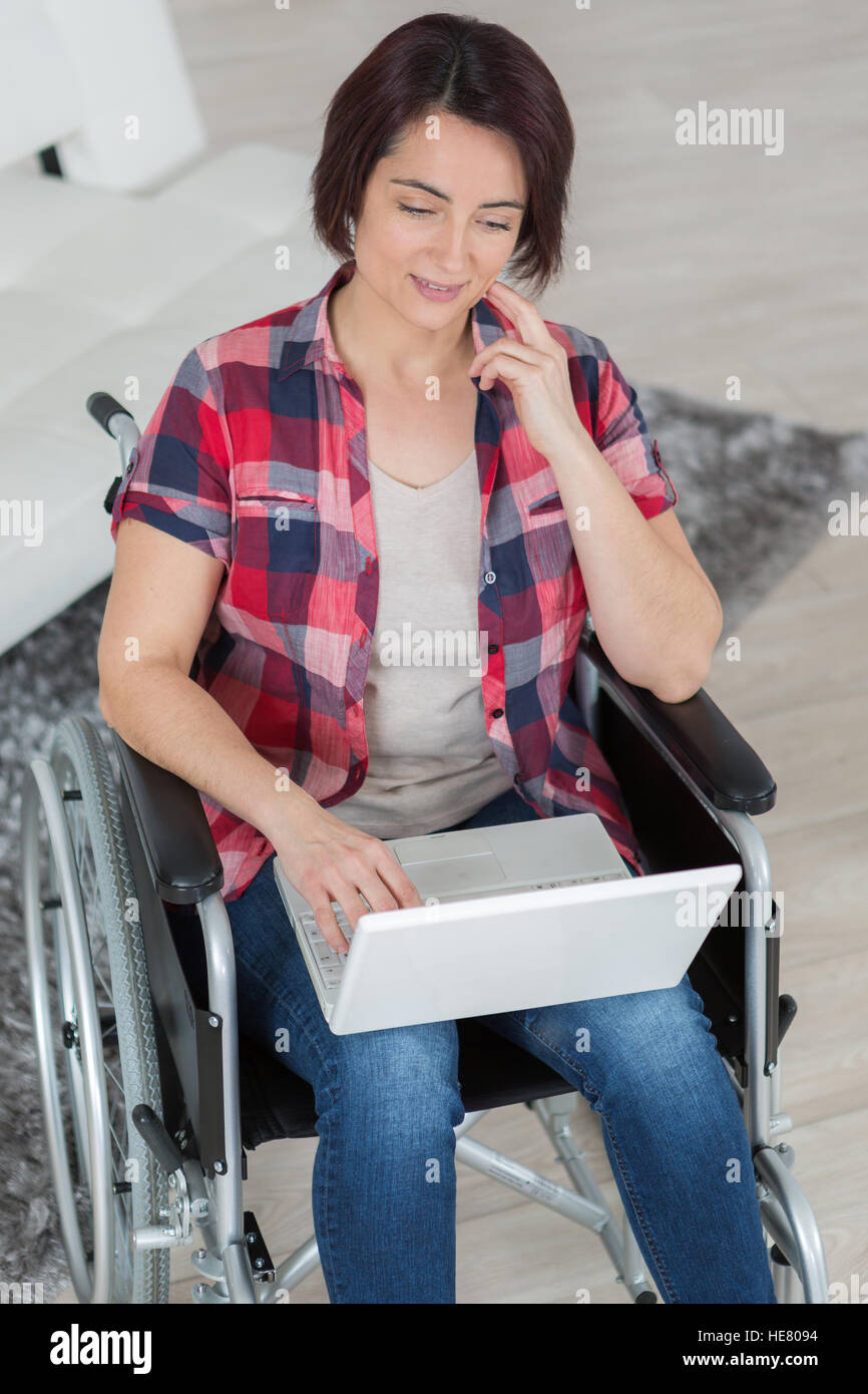 disabled woman in wheelchair using laptop at home Stock Photo - Alamy