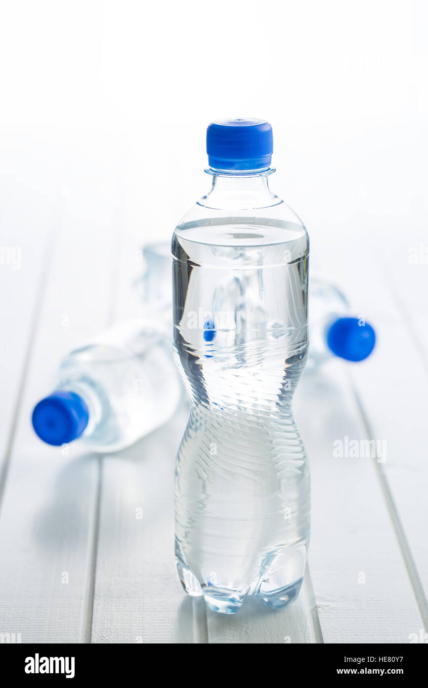 Small plastic water bottle on white table Stock Photo - Alamy