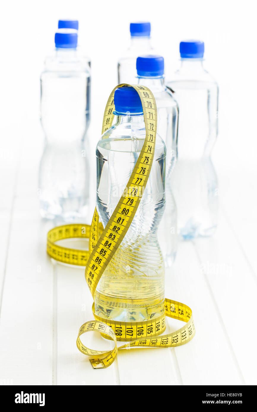 Water bottle and measuring tape on white table. Stock Photo